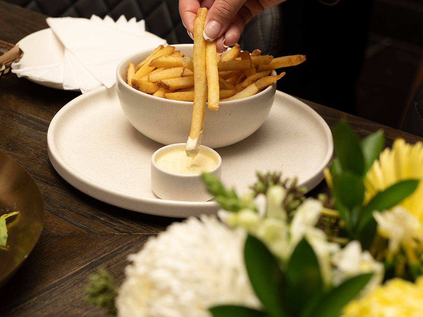 A hand dipping a fry into aioli, fresh from the Deschlers kitchen