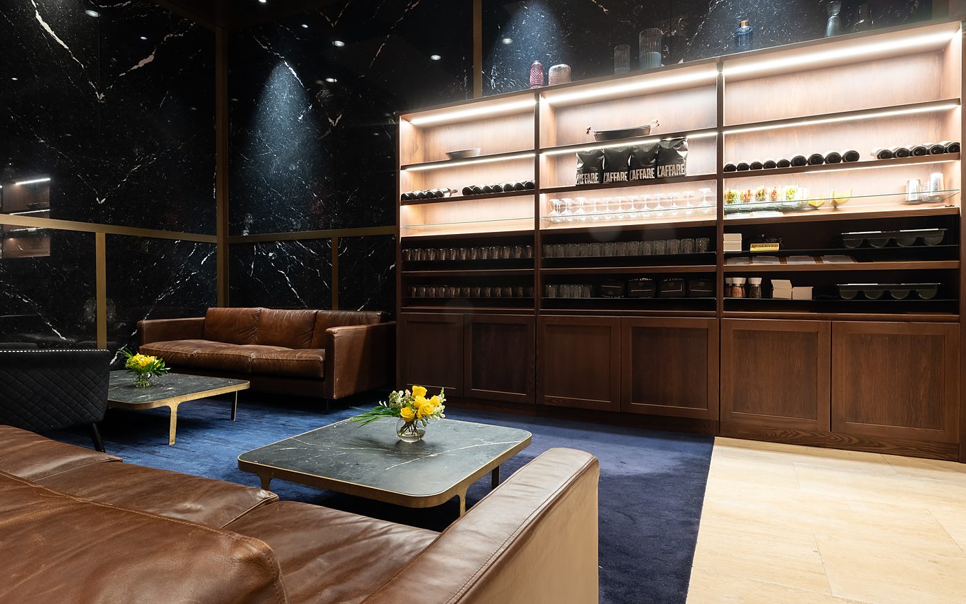 The leather sofa and low table beside the timber shelving